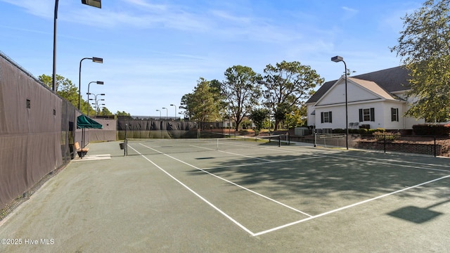 view of tennis court featuring fence