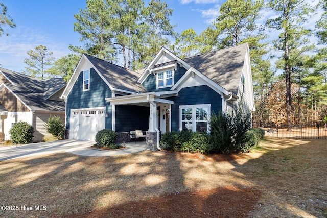 craftsman house featuring a shingled roof, concrete driveway, and fence