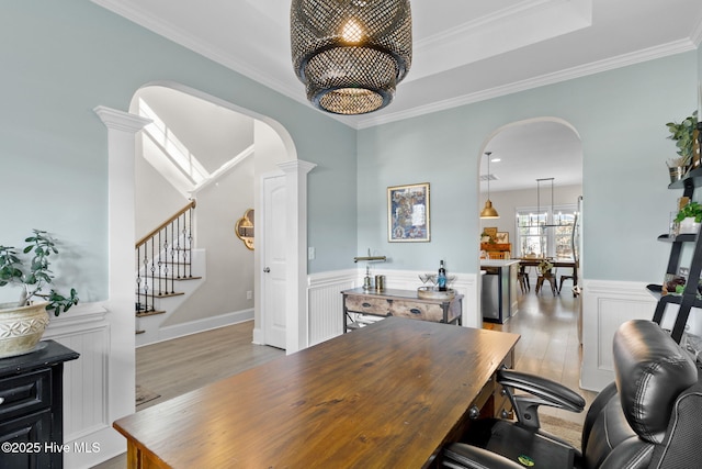 office area featuring a wainscoted wall, wood finished floors, arched walkways, and a chandelier