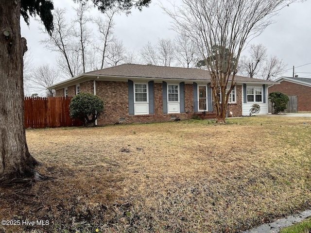 ranch-style home with a front lawn, fence, brick siding, and crawl space