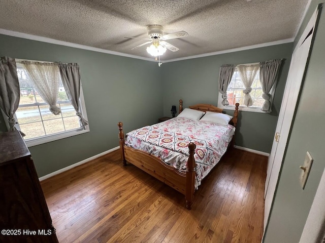 bedroom featuring a textured ceiling, crown molding, baseboards, and hardwood / wood-style floors