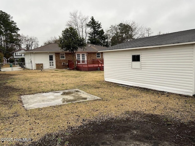 back of house featuring a wooden deck and a yard