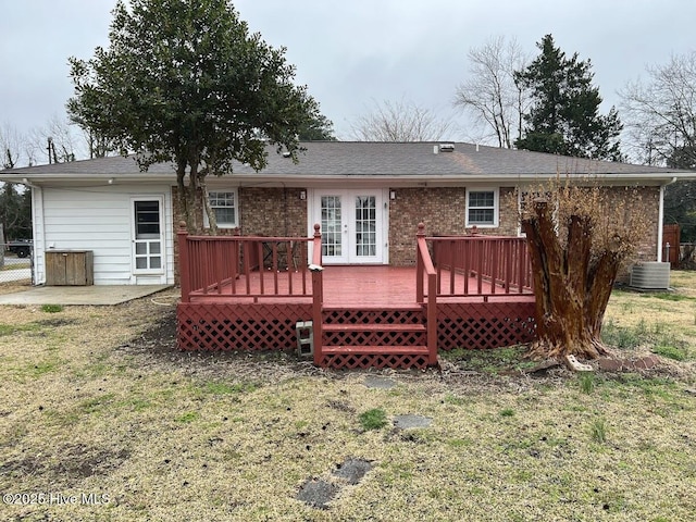 rear view of property with french doors, cooling unit, brick siding, and a wooden deck