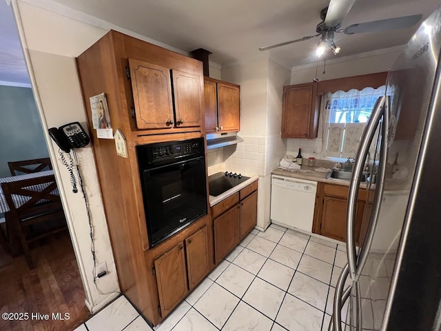 kitchen with ceiling fan, light countertops, decorative backsplash, brown cabinetry, and black appliances