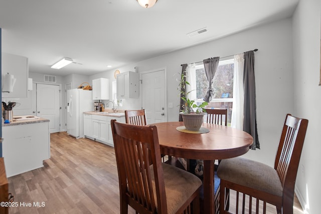 dining area with visible vents and light wood-style floors