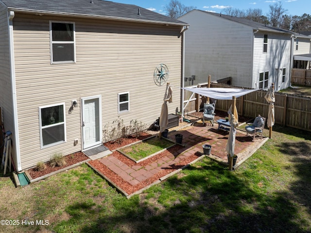 rear view of property with a patio, a yard, and fence