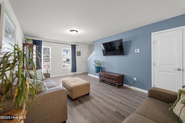 living area with baseboards and wood finished floors