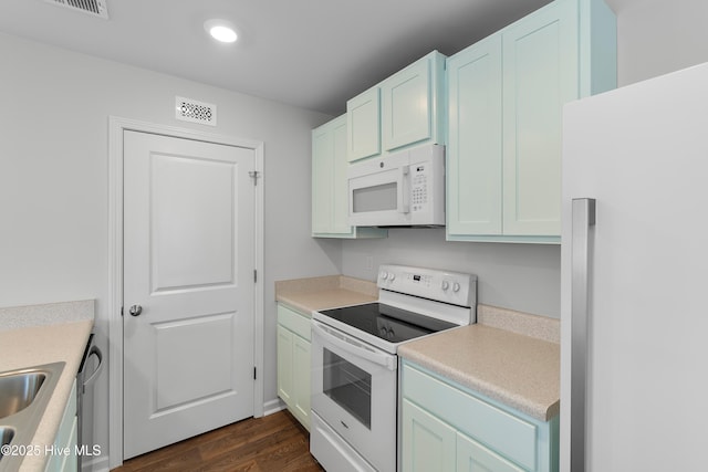 kitchen featuring white appliances, visible vents, recessed lighting, light countertops, and dark wood-type flooring