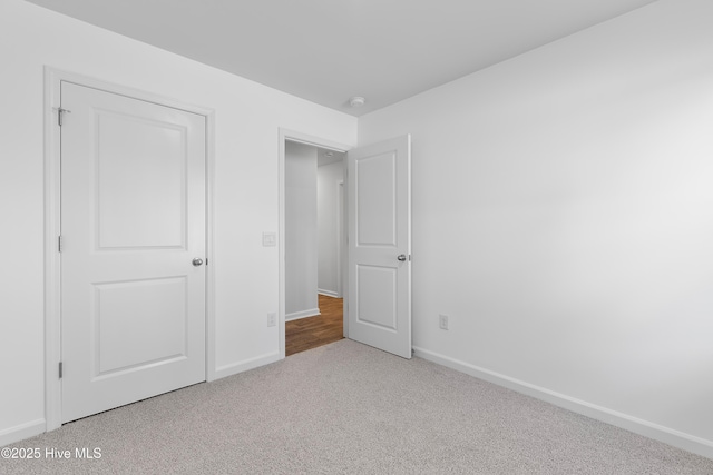 unfurnished bedroom with baseboards and carpet