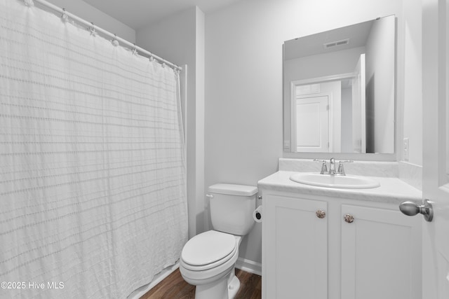 bathroom with visible vents, baseboards, toilet, wood finished floors, and vanity