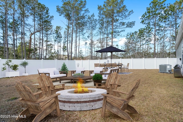 view of patio with central air condition unit, a fenced backyard, and an outdoor fire pit