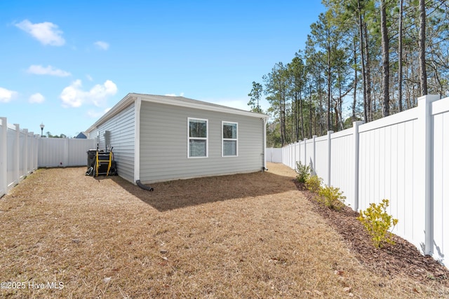 view of property exterior with a yard and a fenced backyard