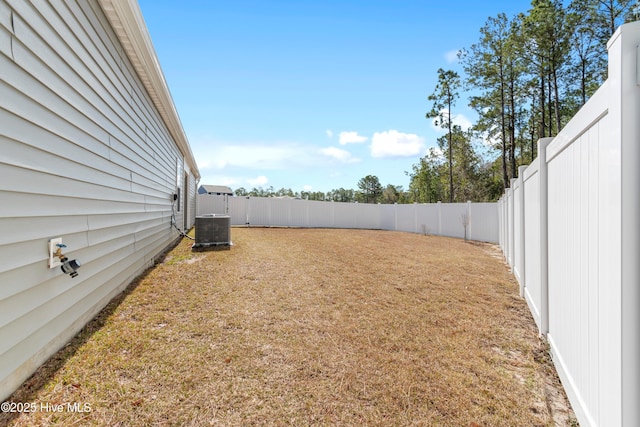 view of yard with a fenced backyard and central AC