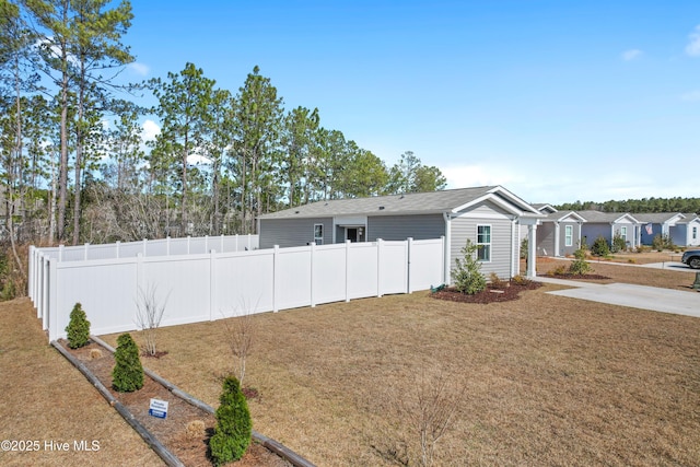 view of front of home with a front yard and fence