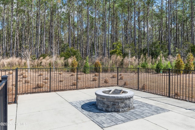 view of patio featuring a fire pit and fence