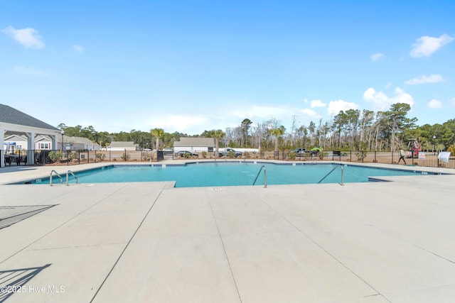 community pool featuring a patio and fence