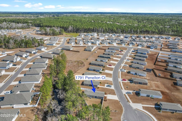 bird's eye view with a wooded view and a residential view