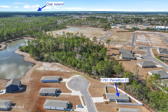 birds eye view of property with a wooded view and a water view