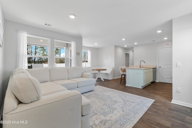 living area with dark wood finished floors, recessed lighting, visible vents, and baseboards