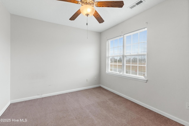 unfurnished room featuring ceiling fan, carpet, visible vents, and baseboards