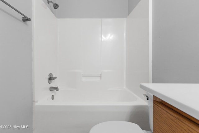 bathroom featuring vanity, shower / bathing tub combination, and toilet