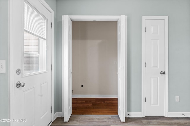 corridor featuring wood finished floors and baseboards