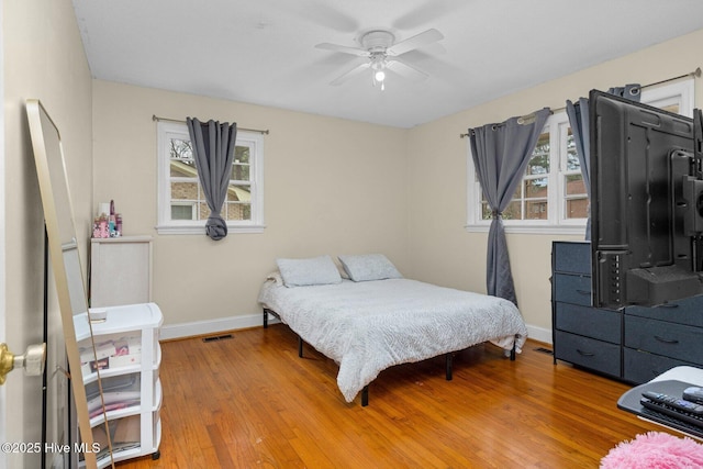 bedroom featuring visible vents, baseboards, and wood finished floors