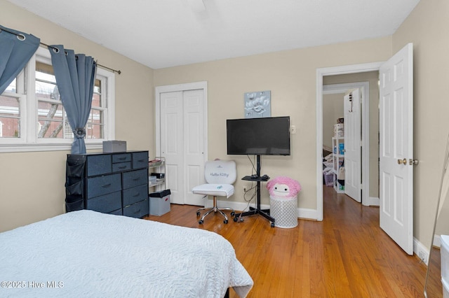 bedroom featuring a closet, light wood-type flooring, and baseboards