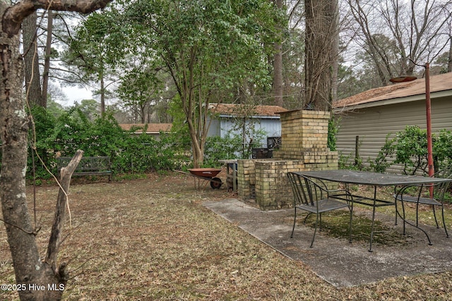 view of yard with outdoor dining area, a patio, and fence