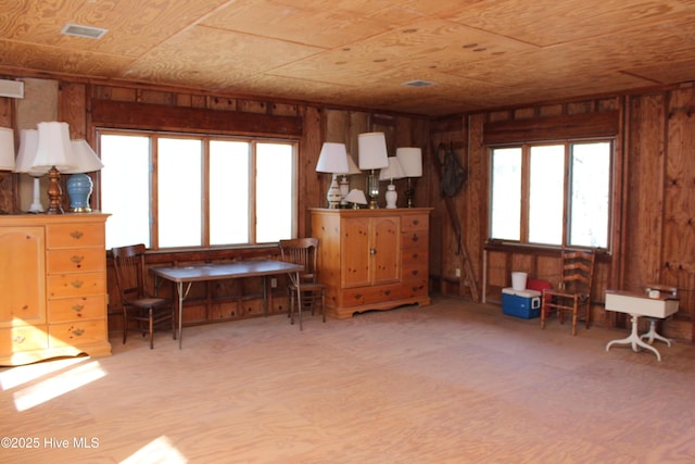 living area with visible vents and wood walls