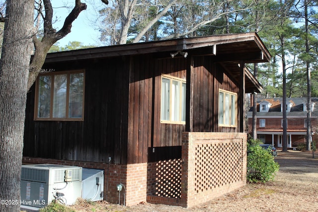 view of property exterior featuring central air condition unit and brick siding