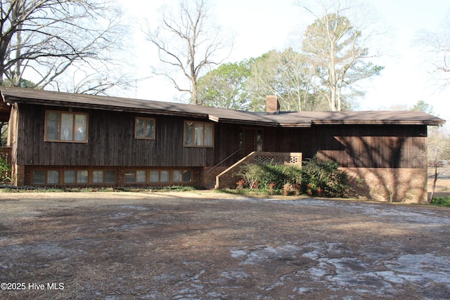 view of front of home with brick siding and a chimney