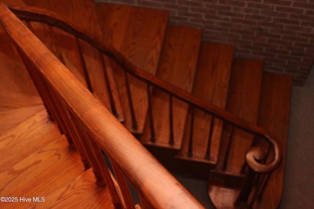 staircase featuring brick wall