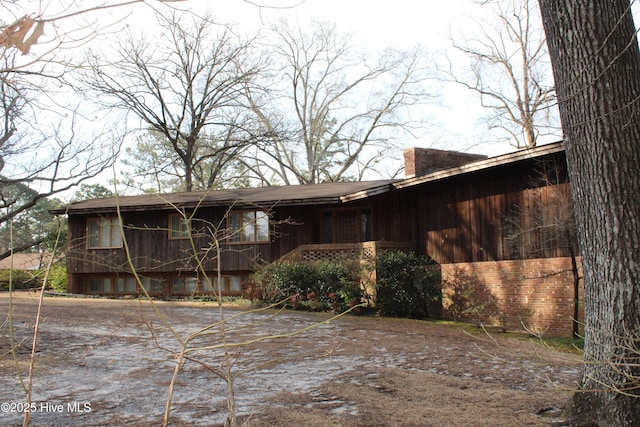 exterior space with brick siding and a chimney