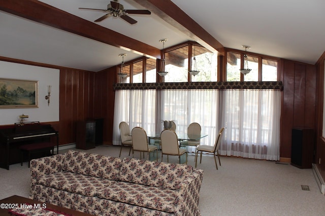 living area featuring light carpet, a ceiling fan, lofted ceiling with beams, a baseboard heating unit, and wood walls