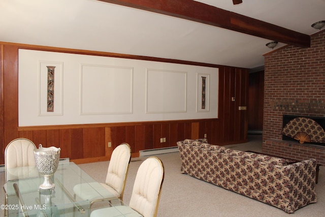 carpeted dining space featuring a baseboard heating unit, a brick fireplace, vaulted ceiling with beams, and wood walls