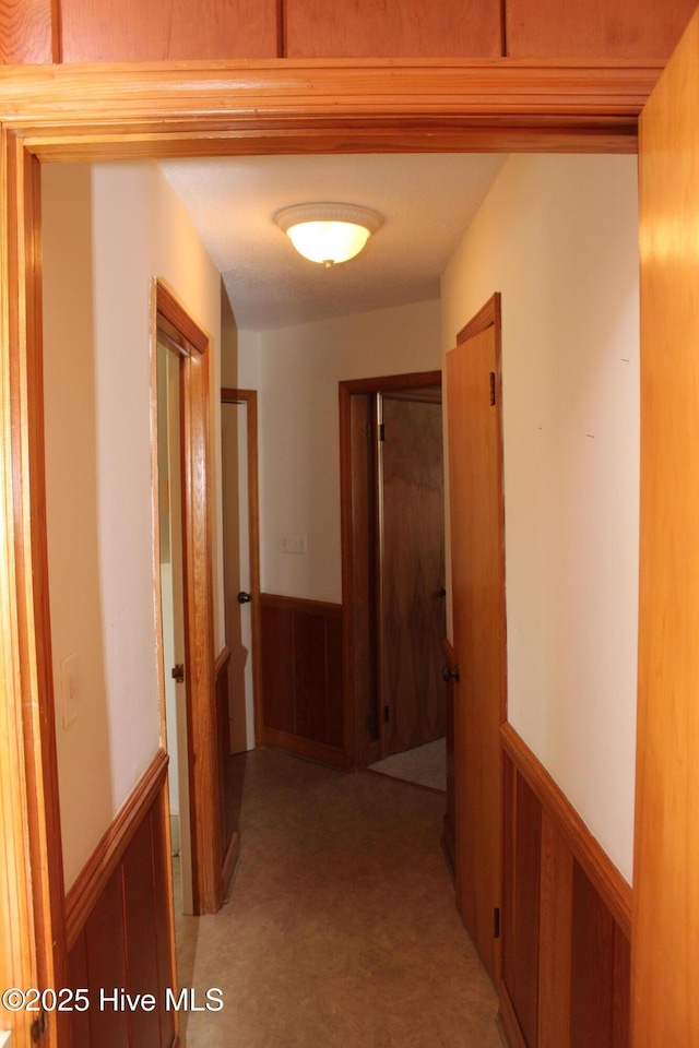 hallway with wood walls and wainscoting