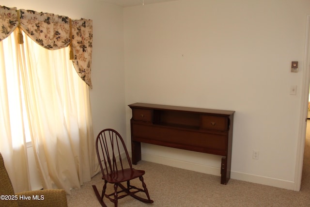 sitting room featuring carpet flooring and baseboards