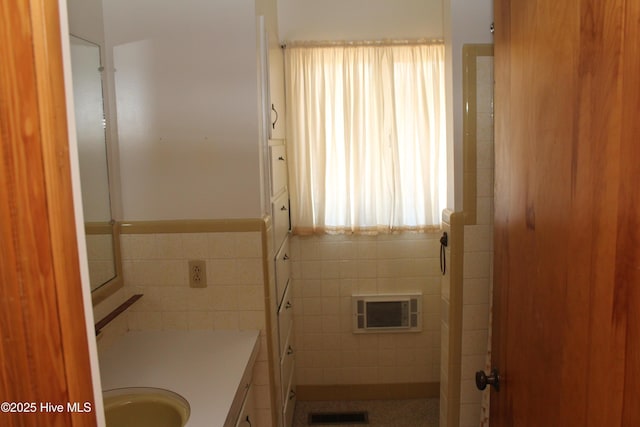 bathroom featuring visible vents, tile walls, and vanity