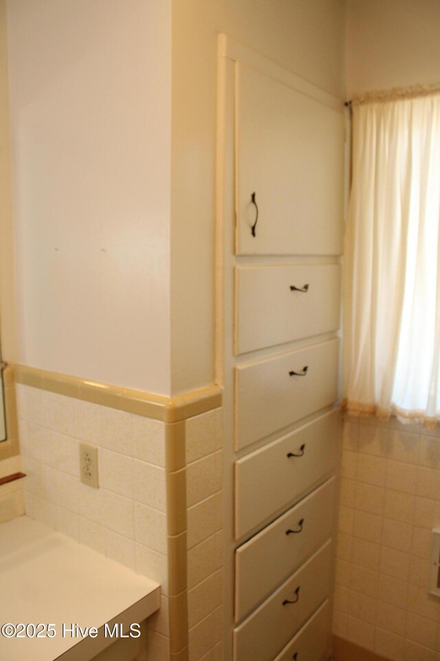 bathroom with a wainscoted wall and tile walls