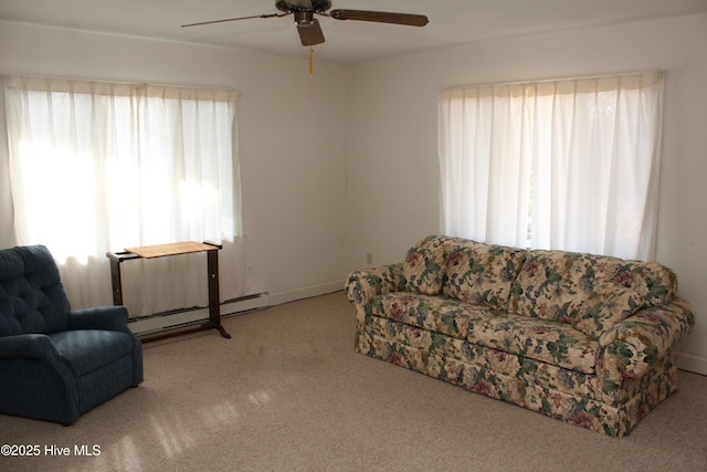 carpeted living room featuring a wealth of natural light, baseboard heating, and a ceiling fan