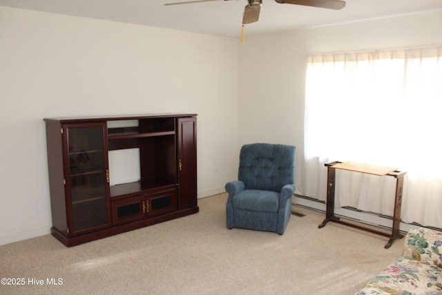 living area featuring baseboards, ceiling fan, and carpet floors