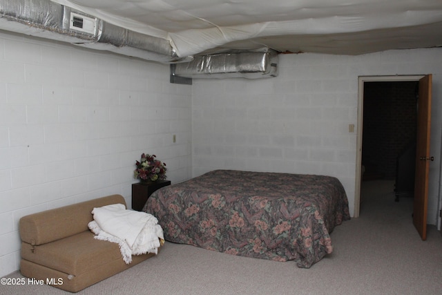 carpeted bedroom featuring concrete block wall