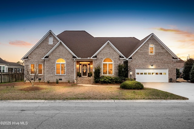 view of front of home featuring brick siding, concrete driveway, a garage, and fence