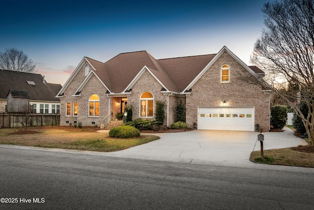 traditional home featuring a garage, driveway, fence, crawl space, and brick siding