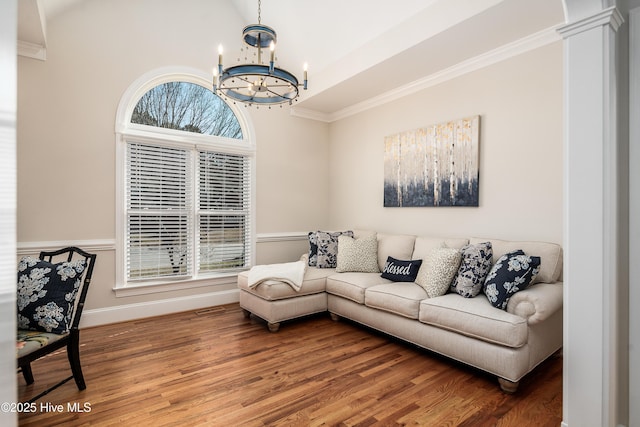 living room featuring a notable chandelier, a healthy amount of sunlight, crown molding, and wood finished floors