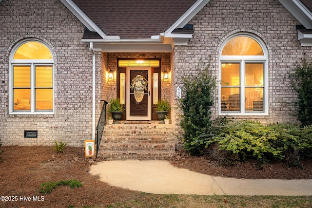 property entrance with brick siding, crawl space, and roof with shingles