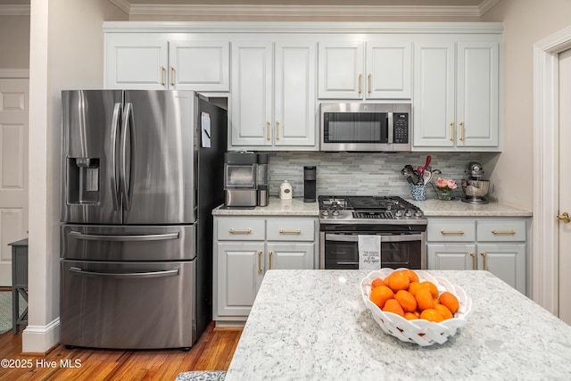 kitchen featuring tasteful backsplash, white cabinetry, light wood finished floors, and stainless steel appliances