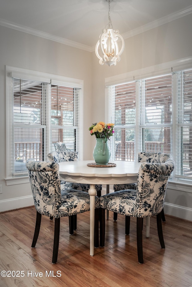 dining space with a notable chandelier, wood finished floors, baseboards, and ornamental molding