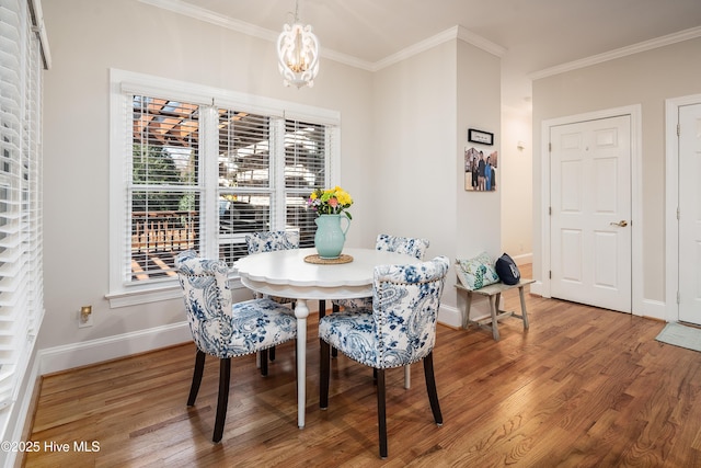 dining area featuring an inviting chandelier, wood finished floors, baseboards, and ornamental molding